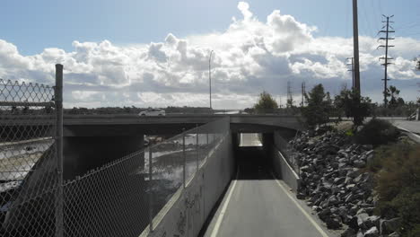 bike path along a river under a highway overpass