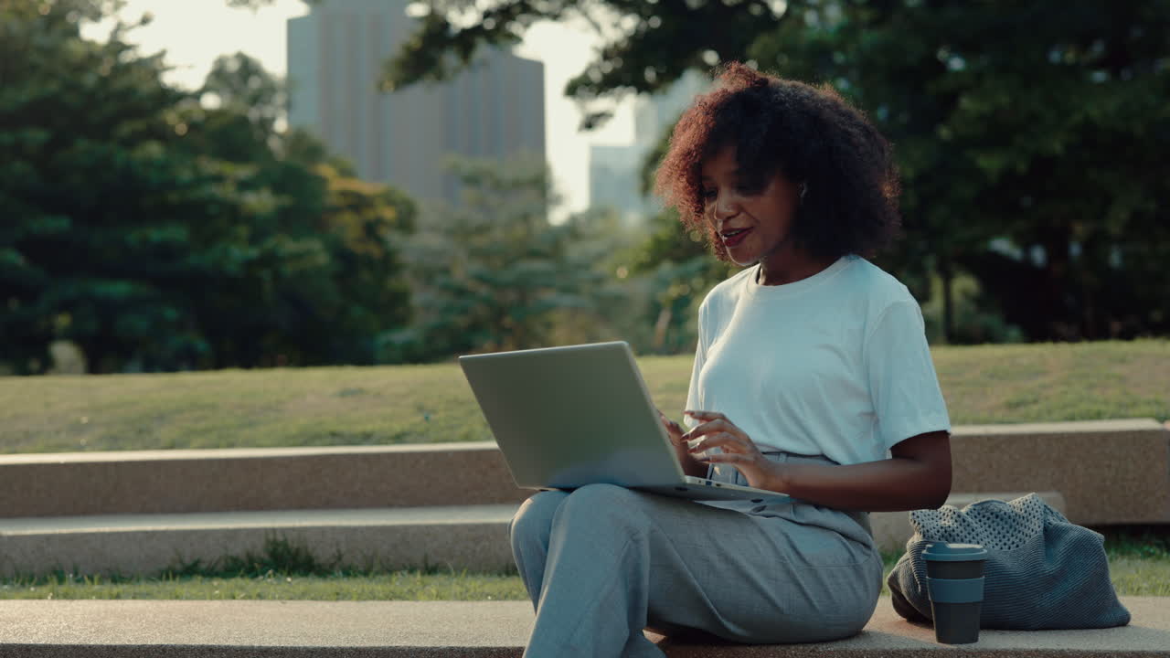 Woman working on laptop in park