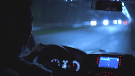 the male driving the car on the night rainy road