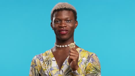 transgender man holding and showing a bitcoin coin standing on an isolated background.