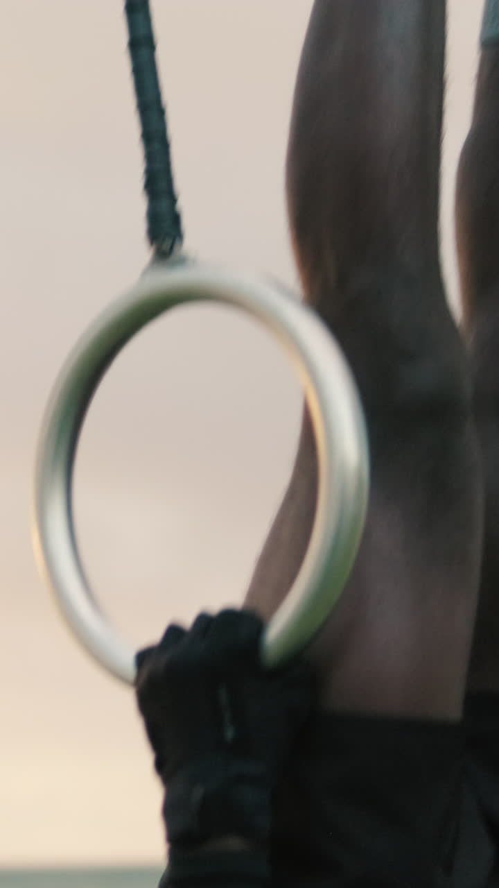 Athlete Hanging Upside Down on Gymnastic Rings