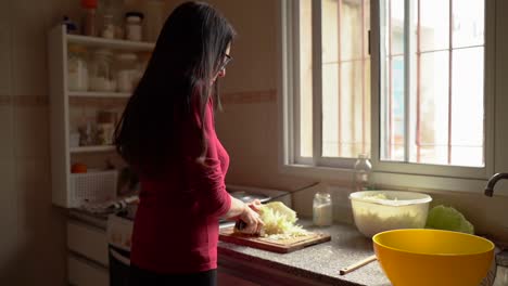 una mujer haciendo repollos finamente picados para chucrut