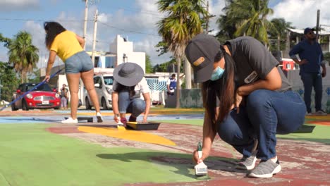 Women-Wearing-Masks-To-Team-Paint-Restore-An-Urban-Basketball-Court