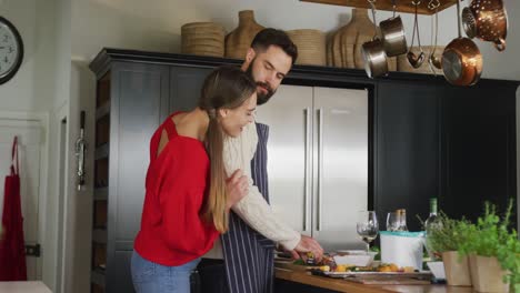 Video-of-happy-caucasian-couple-cooking-in-the-kitchen