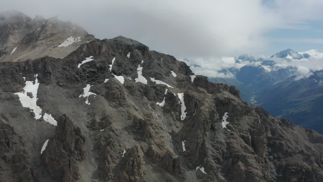volando sobre la cima de la montaña con nieve descongelada en las rocas
