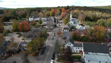 aerial view of wolfeboro town, main street, houses, first christian church, fall foliage and traffic, drone shot