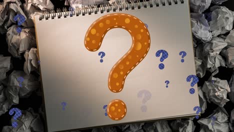 Animation-of-question-marks-over-notebook-and-paper