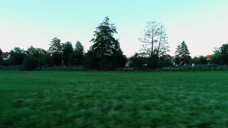 a drone flies sideways close to the ground over the grass on a green meadow