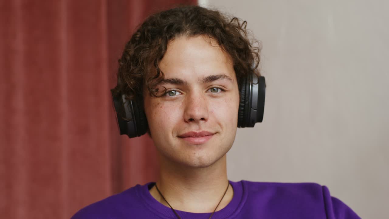 Giovane che indossa le cuffie e una felpa viola