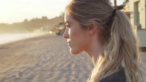 primer plano de la cara de una mujer mientras camina por la playa