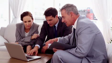 Business-people-on-a-couch-working-on-a-laptop-