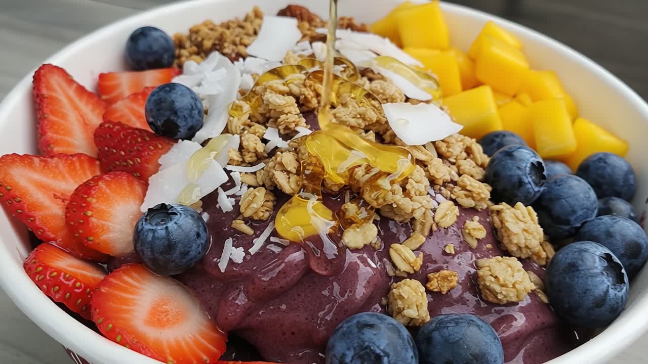 A Vibrant and Healthy Acai Bowl Topped with Fresh Fruits, Crunchy Granola, and Drizzled Honey for a Delicious and Nutritious Treat