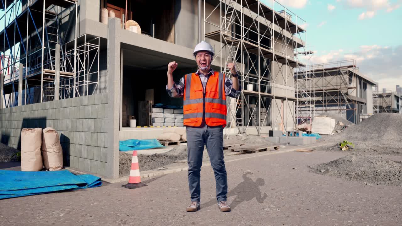 Full Body Of Asian Male Engineer With Safety Helmet Screaming Goal Celebrating Working At Building & Construction Site in Progress to New House