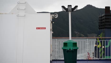 'no smoking' sign at the aft of a ferry that steers through coastal waters of new zealand on an overcast evening