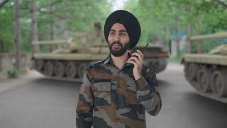 happy sikh indian army man giving instructions on walkie talkie