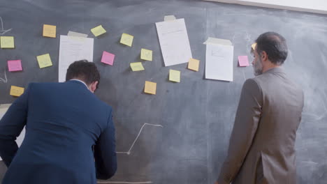 two male colleagues working together in boardroom