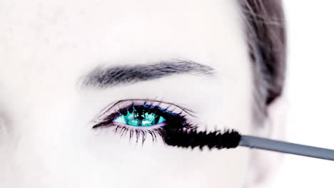 blue eyed woman making up with mascara