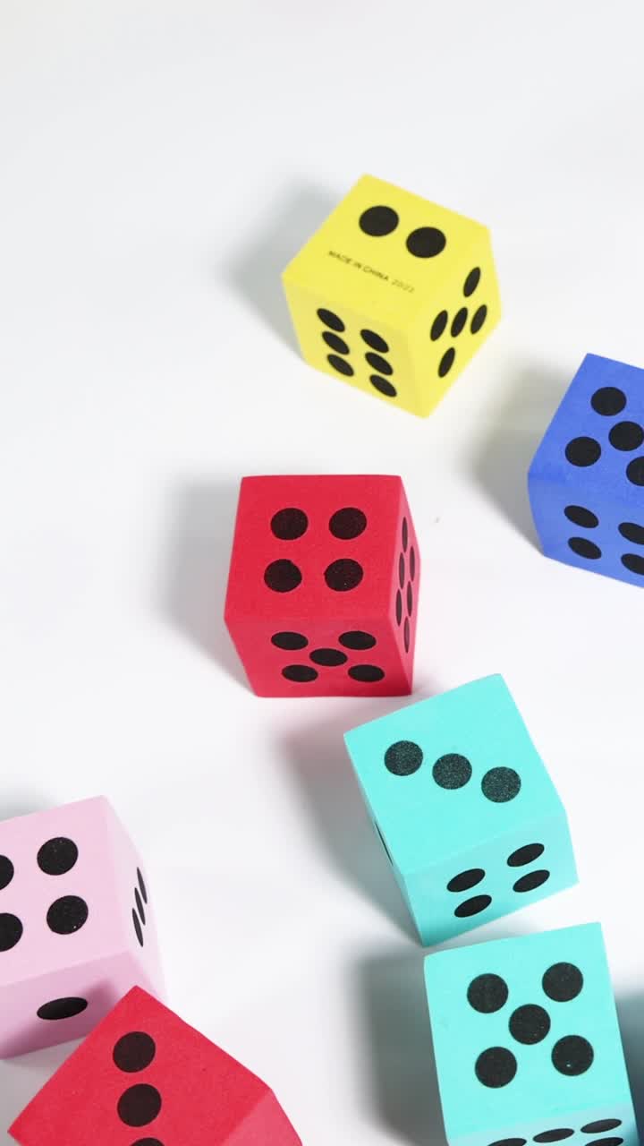 mano soltando dados coloridos contra un fondo blanco