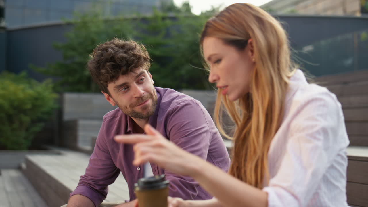 радостная пара наслаждается общением в парке вблизи. красивая девушка рассказывает историю