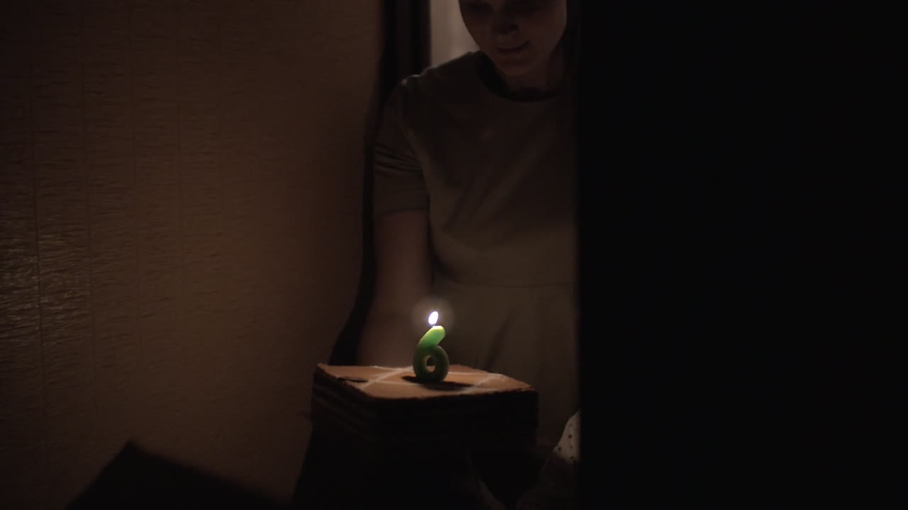 엄마와 아들은 여섯 번째 생일 케이크를 가지고 있습니다.