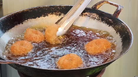 frying doughnuts in a wok