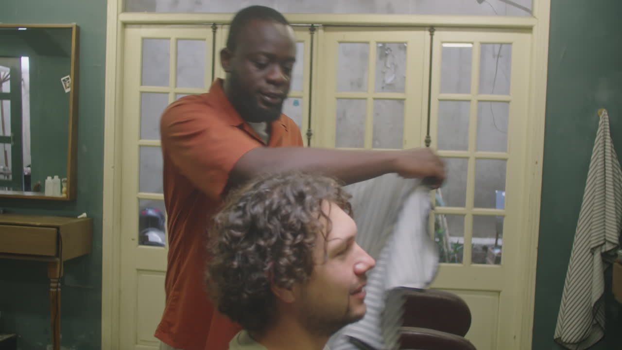 Barber Putting Hairdressing Cape and Chatting with Client