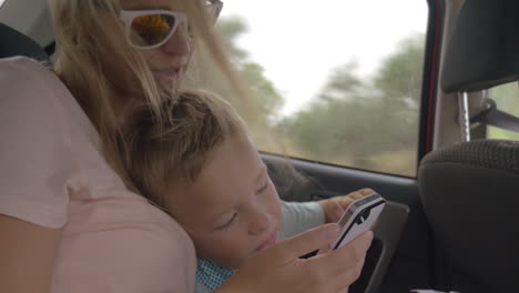 mother and child video chatting on mobile in car