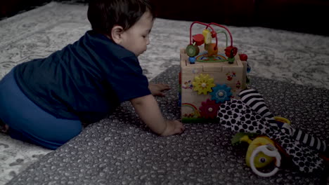 baby plays with colorful toys on the carpet