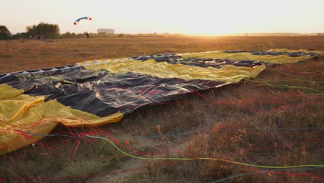 Fallschirm-Liegt-Auf-Dem-Boden-In-Den-Sonnenuntergangsstrahlen-Der-Sonne-Auf-Dem-Flugplatz