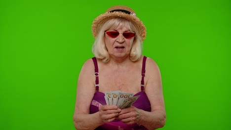 mujer turista anciana rica contando dinero disfrutando de la independencia financiera, agitando billetes de dólar ingresos
