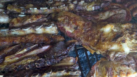 Close-up-shot-of-crispy-and-roasted-pieces-of-chicken-and-beef-in-Argentinian-asado