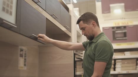 man choosing kitchen cabinets in a store