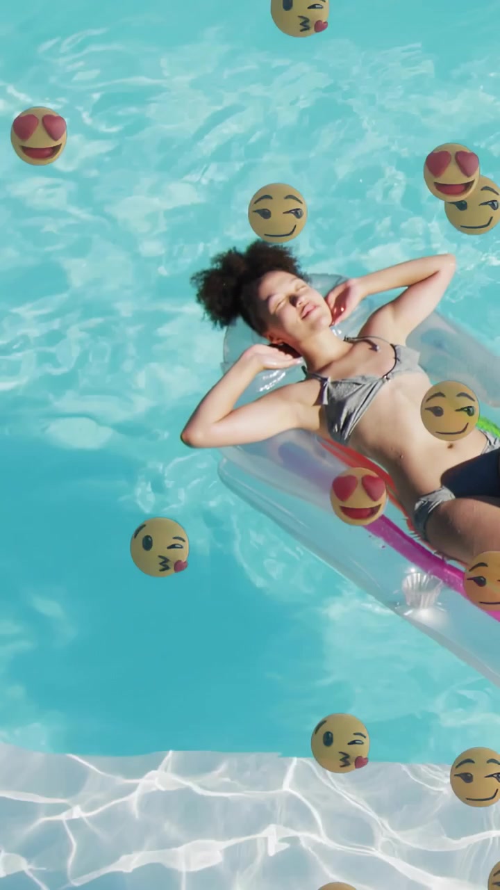 Woman reclining on float in blue pool, emojis appearing and drifting causing smile for marketing