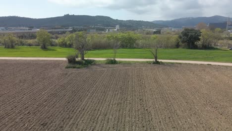 Aerial-rising-over-soil-after-harvest-in-rural-landscape