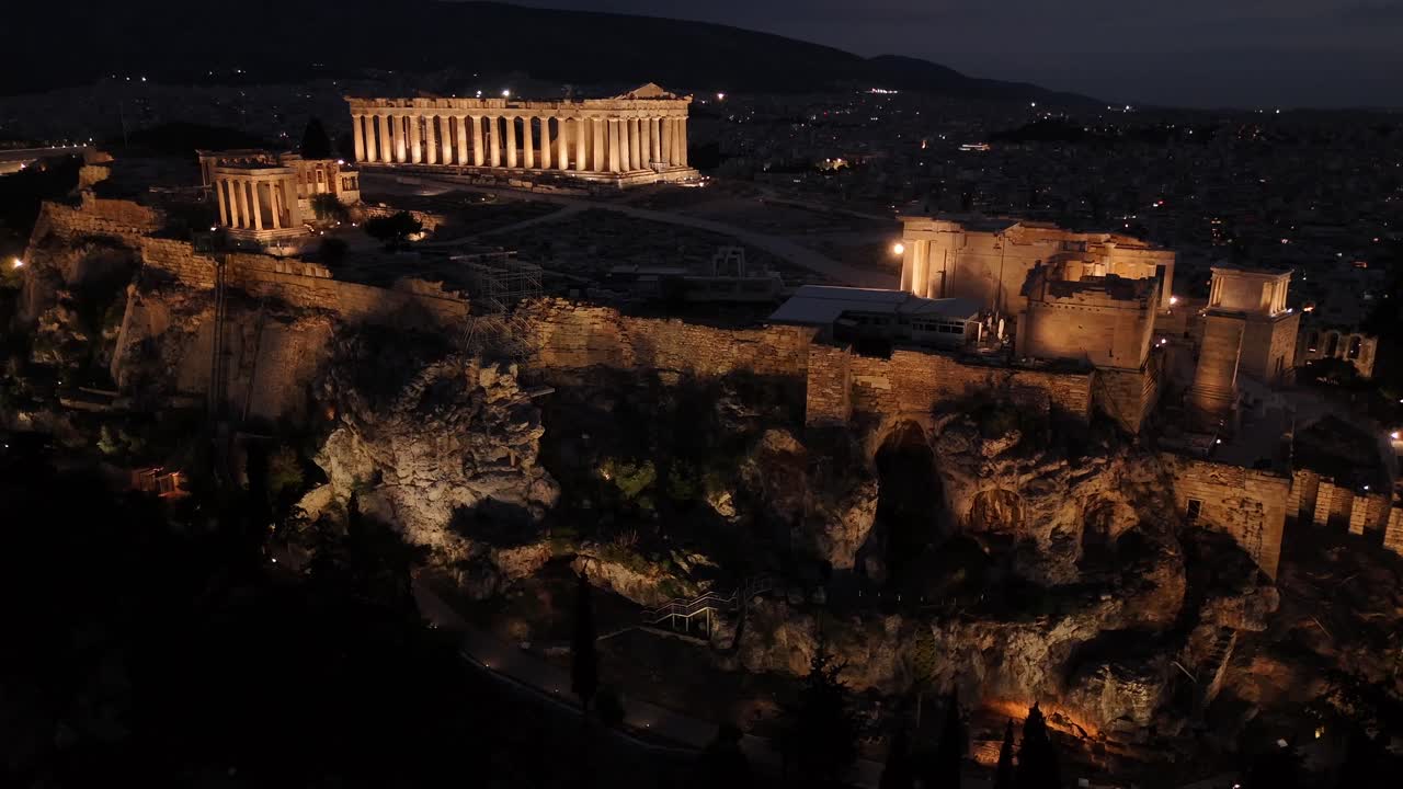 Athens, Aerial view of Beautifully illuminated Acropolis at night from a distance,drone shot tilt up