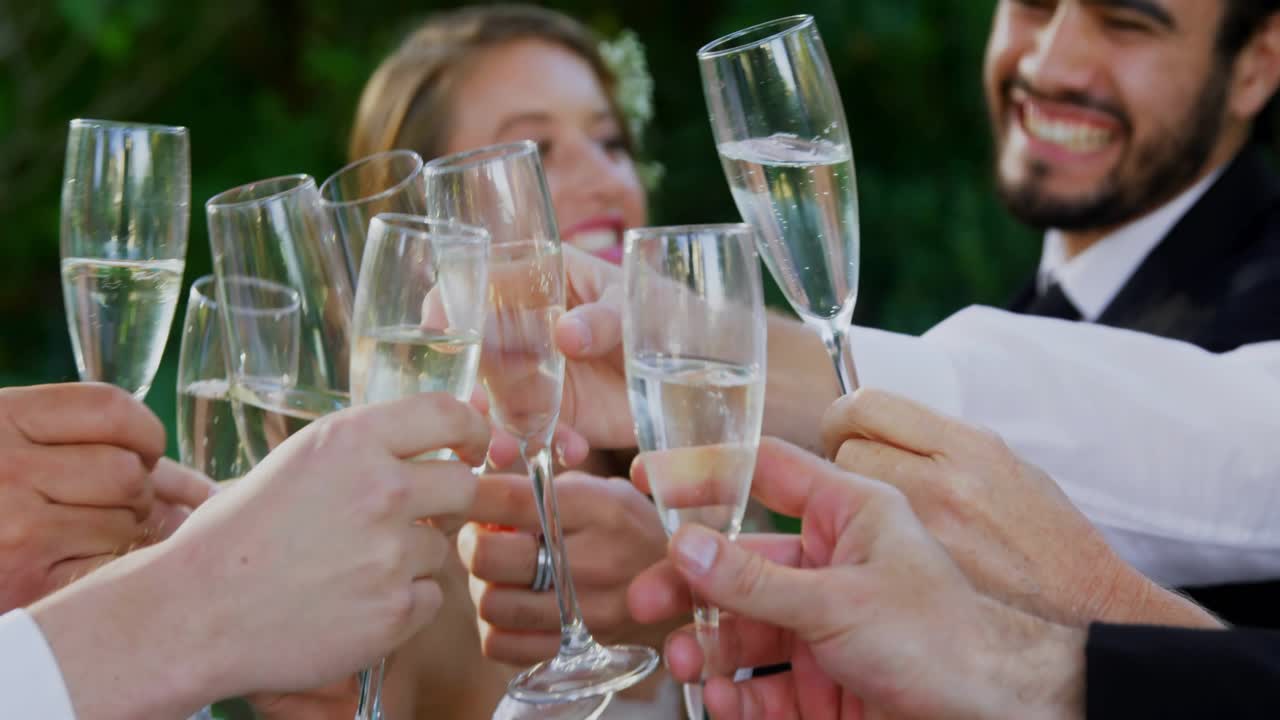 Wedding guests raising flutes and clinking, celebrating couple, causing binary overlay over glasses