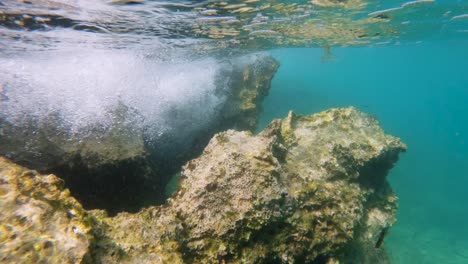 underwater shot of waves crashing against rocks in adriatic sea