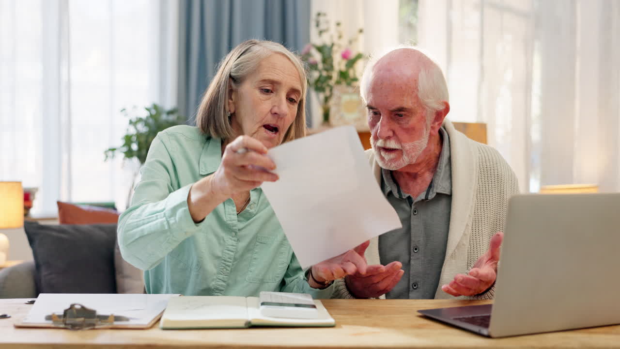 Elderly couple reviewing financial documents at home