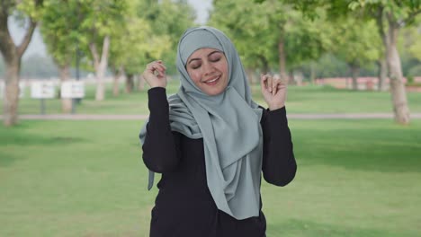 happy muslim woman dancing and enjoying in park