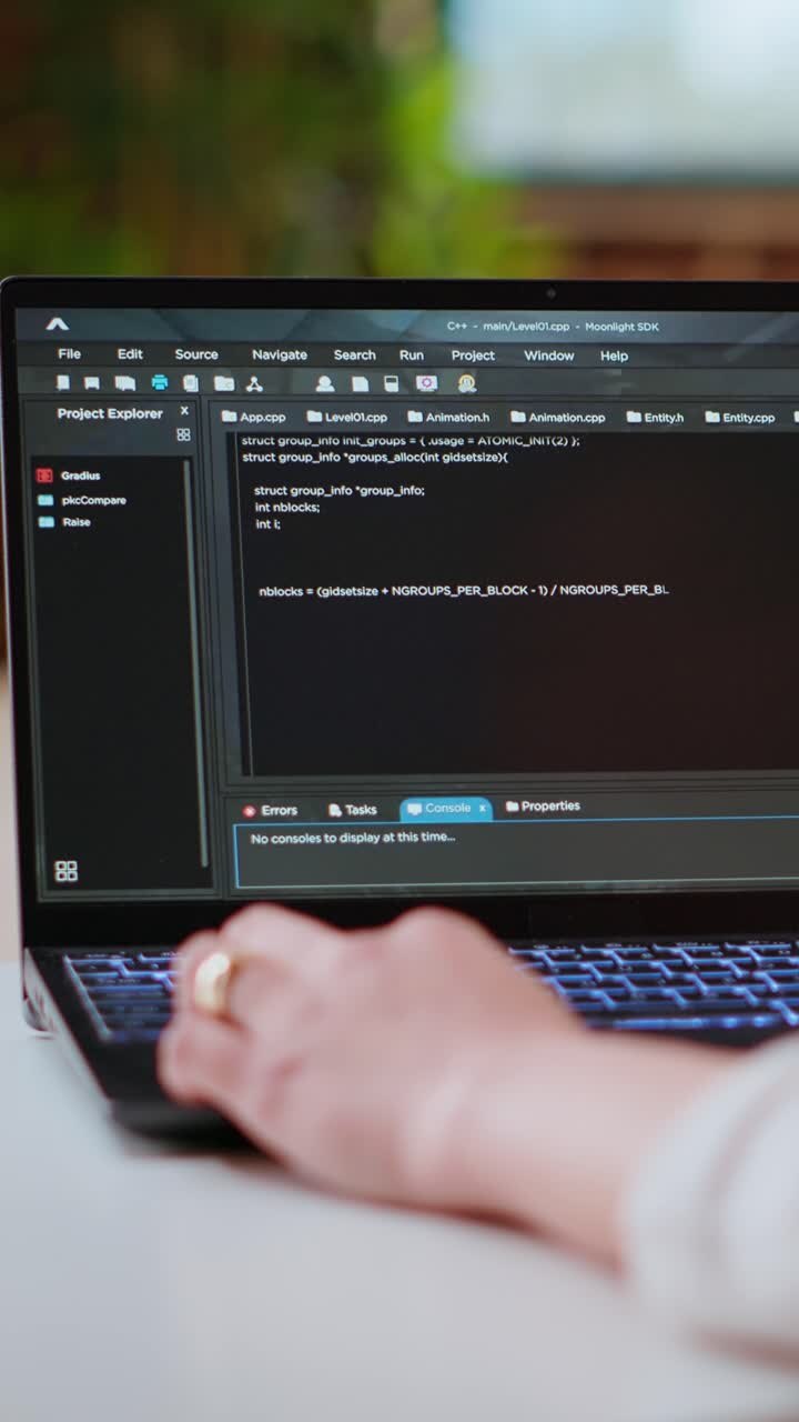Vertical Video Asian female programmer works on coding software in a home office setup