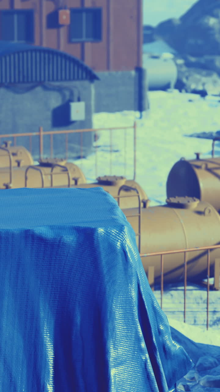 Colorful containers and tarps rest under a clear blue sky in a remote setting
