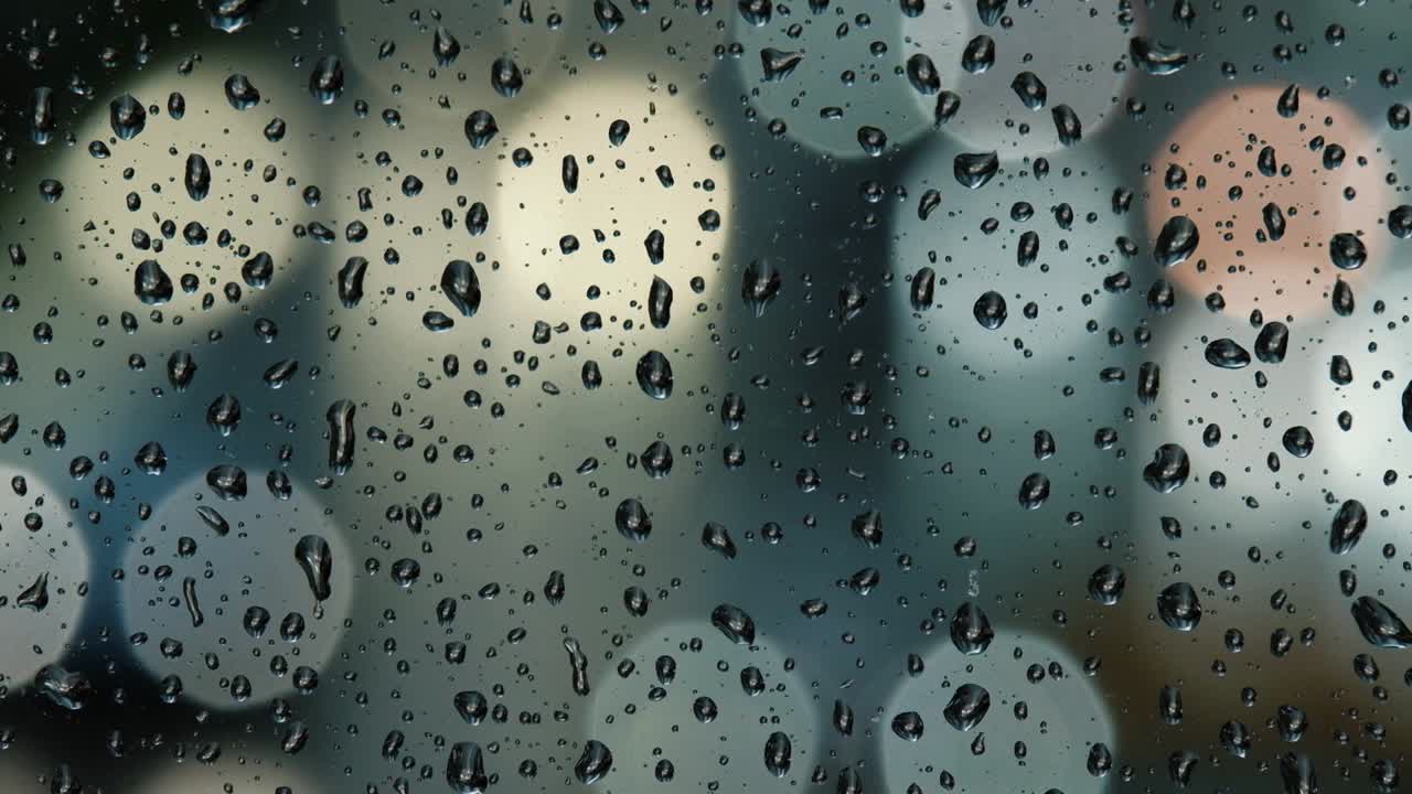 비가 오는 밤에 거리 조명과 자동차의 보케, 창문에 비방울.