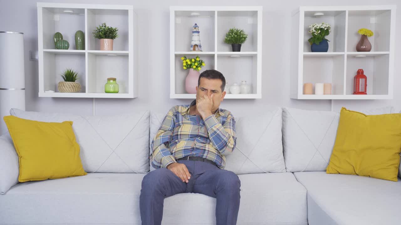 el anciano, que huele el mal olor en la casa, está perturbado por el mal olor.