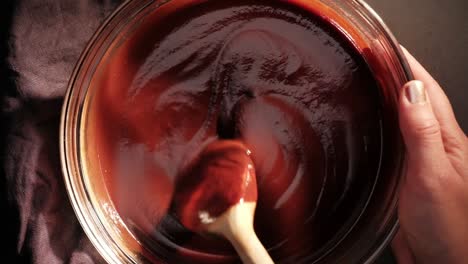 topview of stirring ready chocolate mixture with wooden spoon