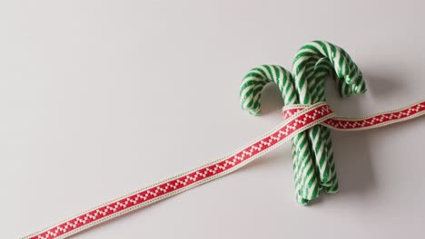 video of green christmas canes with ribbon over white background