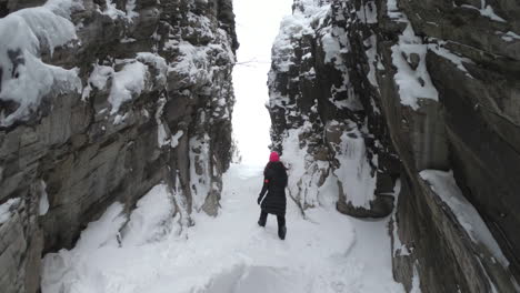 static shot of a girl walking on ice and snow in a big cave in björkliden, sweden