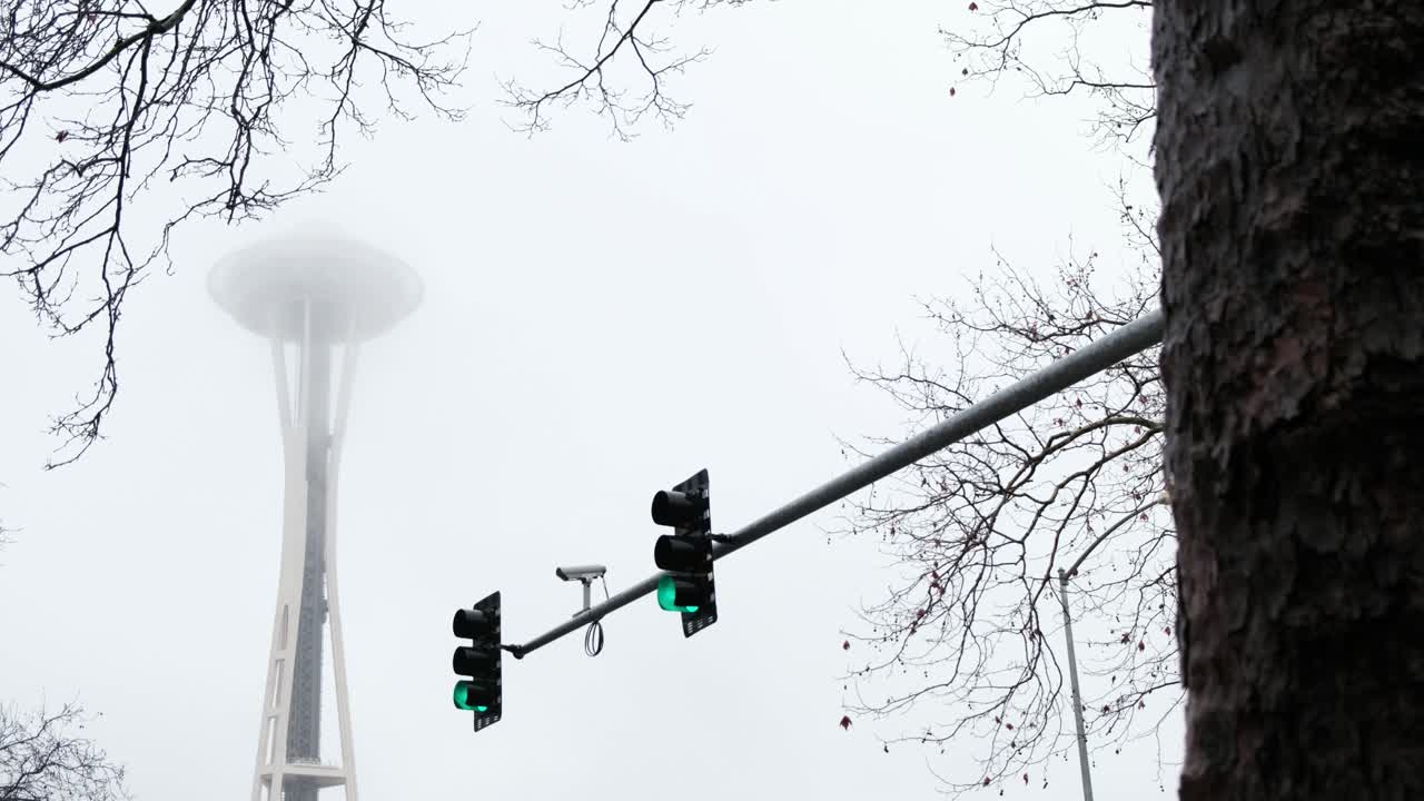Cloudy overcast shot of the futuristic space needle skyscraper observation tower -  It is a city landmark and is considered an icon of Seattle - Surveillance camera on street lights