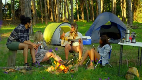 friends having fun near bonfire in the forest 4k