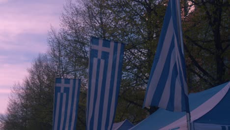 las banderas de grecia cuelgan verticalmente como banderas en la tienda del quiosco del festival