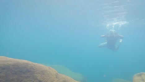 Junger-Mann-Schwimmt-Tagsüber-Aus-Niedrigem-Winkel-Unter-Wasser-In-Klarem,-Blauem-Wasser